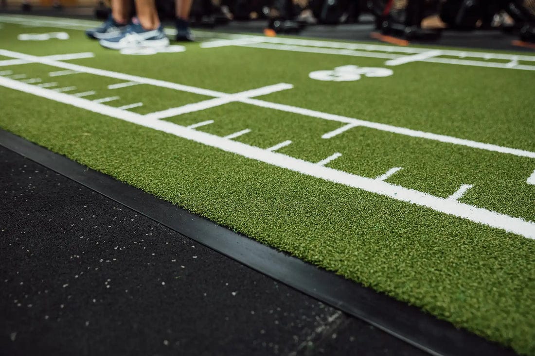 Het stofzuigen van de vloer van de sportschool voordat de grasmat wordt geïnstalleerd
